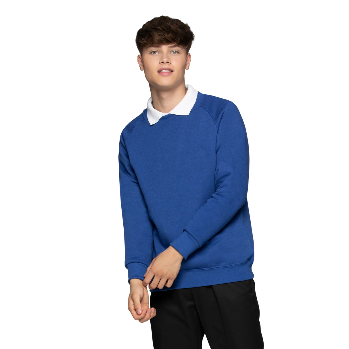 Young man wearing a blue crew neck sweatshirt over a white collared shirt, standing against white background