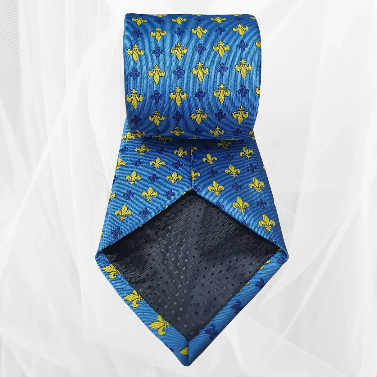 Blue silk tie with yellow and navy fleur-de-lis pattern on white background
