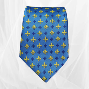 Blue silk tie with yellow and navy fleur-de-lis pattern on a white background