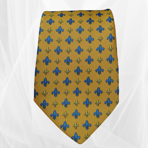 Yellow silk tie with blue and gold fleur-de-lis pattern on white background